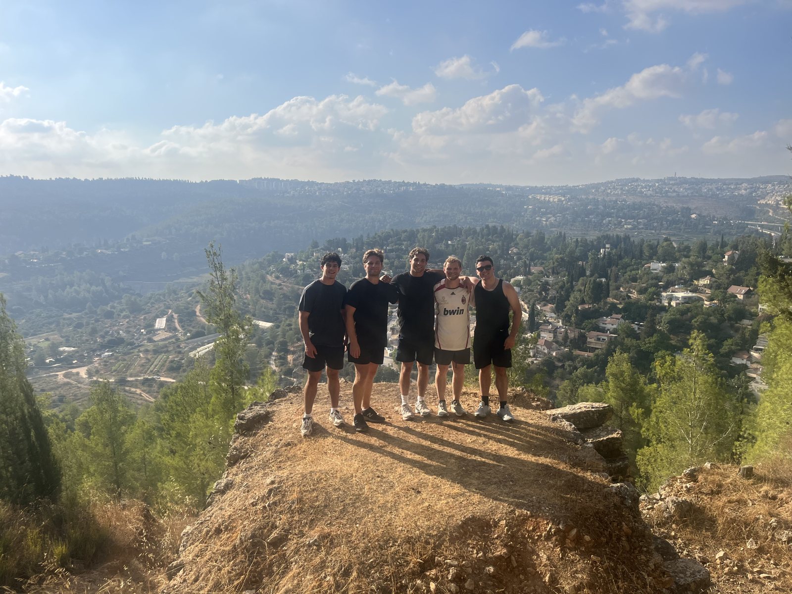Students standing together on a mountain overlook above the Judean hills