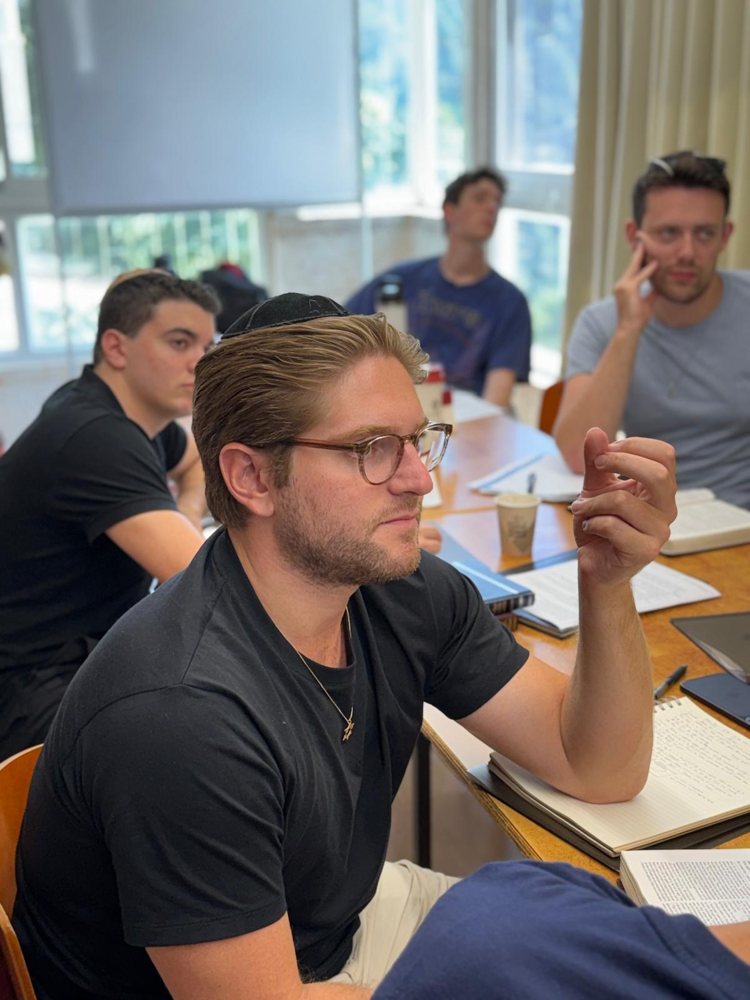 A student in glasses listening closely during a class
